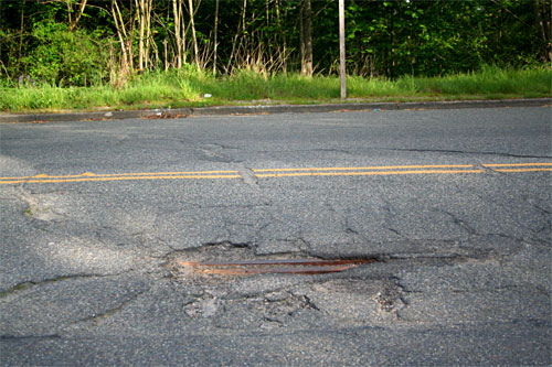 Pothole with train track peeking through