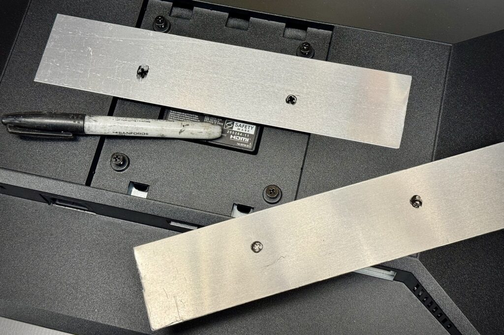 DIY monitor flush wall mount aluminum plates with screw hold positions marked.